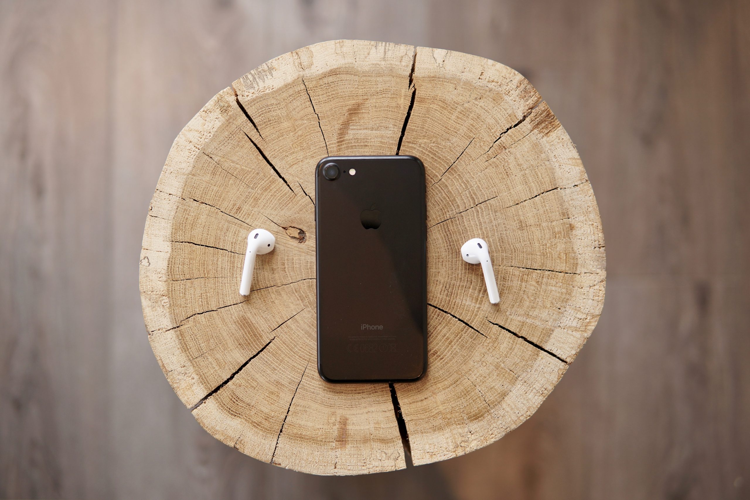 How to Start a Podcast - iPhone on a woodblock with AirPods